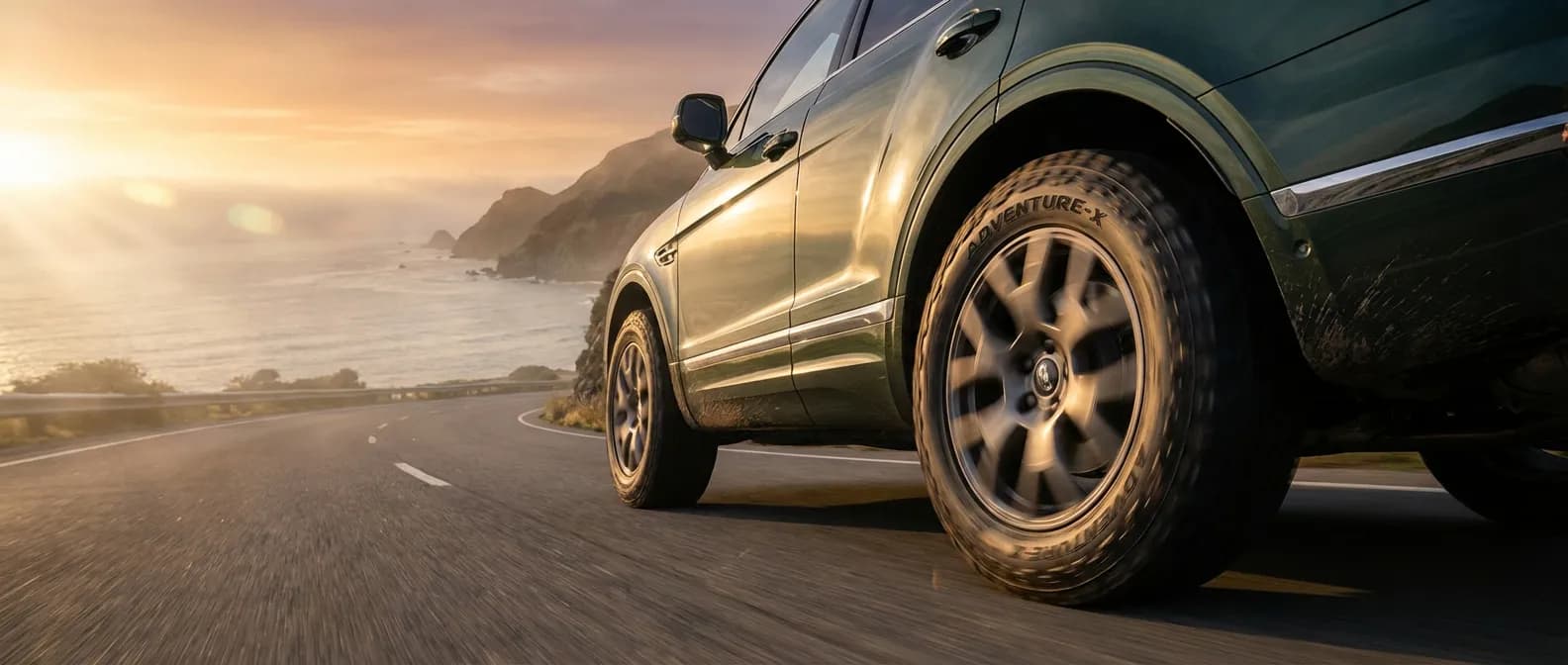 SUV de luxe circulant sur une route côtière au lever du soleil mettant en avant la performance des pneus Léonard.