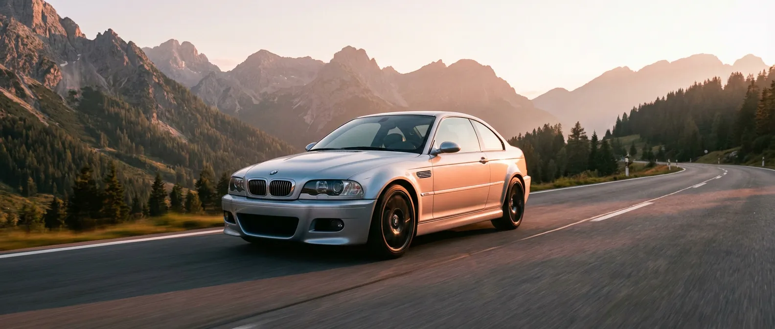 BMW M3 E46 argentée sur une route de montagne au coucher du soleil, style éditorial automobile