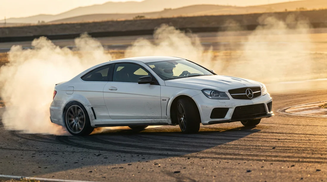 Mercedes C63 AMG W204 Coupé blanche en drift sur circuit avec fumée de pneus