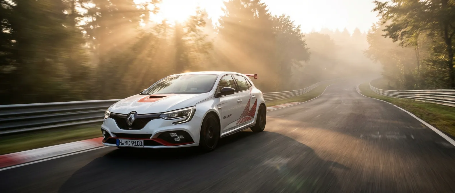 La Mégane 4 Trophy R en pleine action sur le circuit du Nürburgring au lever du soleil.